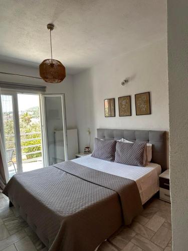 a bedroom with a large bed and a large window at Fiosal Apartments 1 in Skiathos