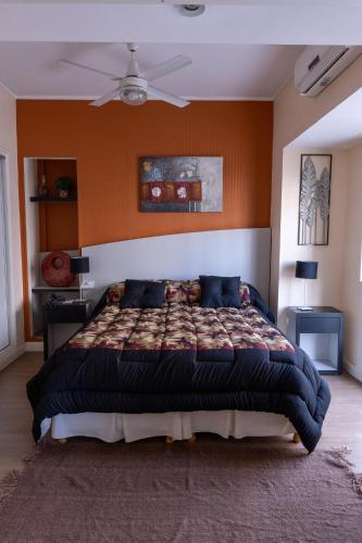 a bedroom with a large bed with an orange wall at Hotel Miami in Mar del Plata