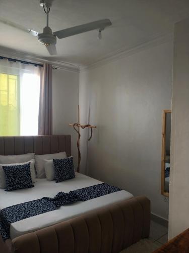 a bedroom with a large bed with a couch at Ardina Studio in Mtwapa