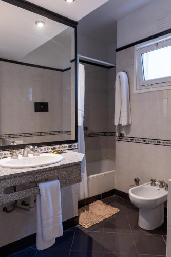 a bathroom with a sink and a toilet and a mirror at Hotel Miami in Mar del Plata