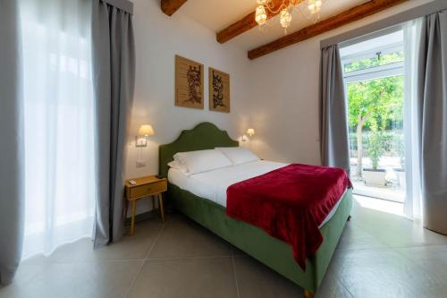 ein Schlafzimmer mit einem Bett und einem großen Fenster in der Unterkunft Itria Palace in Ragusa