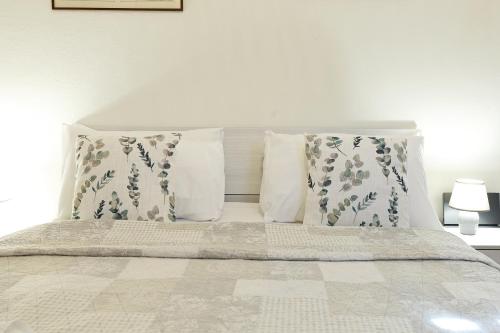 a bed with two pillows and a white bedspread at La Valletta - Casa di Anna in Menaggio