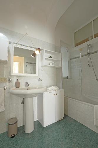 a white bathroom with a sink and a shower at La Valletta - Casa di Anna in Menaggio