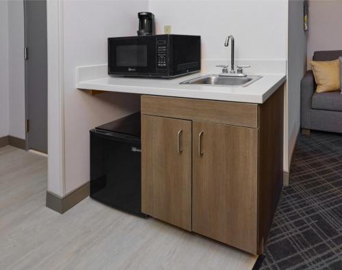 a kitchen with a sink and a microwave at Comfort Suites Springfield-Eugene in Springfield