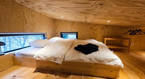 ein Bett in einem Zimmer mit Holzdecke in der Unterkunft Panorama Studio - Sauna, Lakeview & Fireplace in Skaveröd