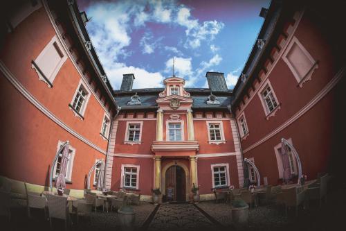 a large red building with a clock on top of it at Pałac Spiż Miłków koło Karpacza in Karpacz