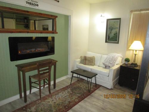 a living room with a white couch and a table at Bunkhouse on Bomoseen in Castleton