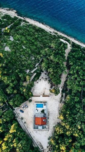 an aerial view of a building on the beach next to the water at Villa Azure Bay in Povlja