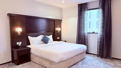a bedroom with a large bed and a window at اجنحة الطائف للشقق المخدومة - AL Taif Suites in Taif