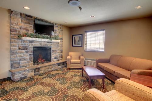 a living room with a couch and a fireplace at Cobblestone Inn & Suites - Harvey in Harvey