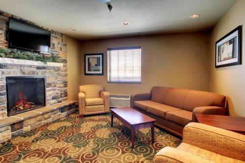 a living room with a couch and a fireplace at Cobblestone Inn & Suites - Harvey in Harvey