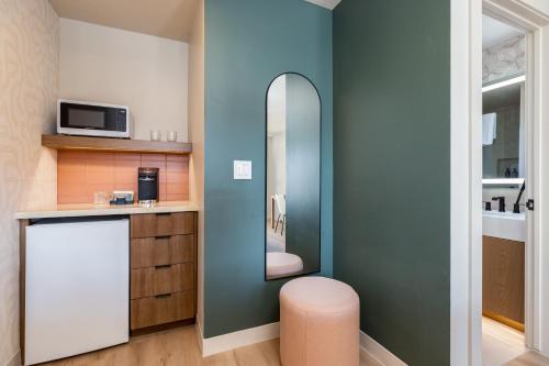 a small kitchen with a mirror and a stool at Adobe Desert in Panguitch