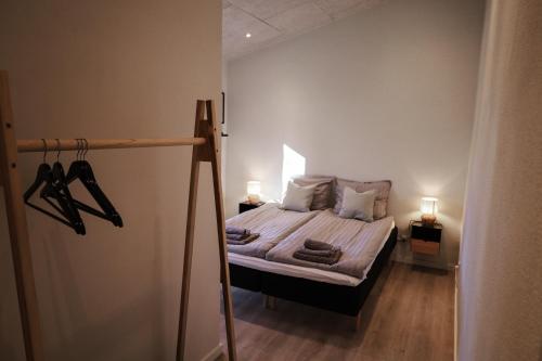 a small bedroom with a bed with two lamps and towels at Billund Guest Lodge in Grindsted