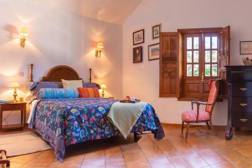 a bedroom with a bed and a desk and a chair at Casa Rural Milagrosa in Valsequillo