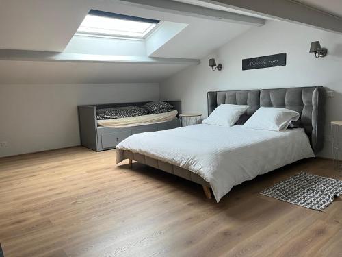 a bedroom with a large bed and a skylight at Gîte de la Galimondaine in Bouguenais