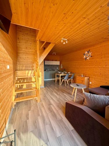 a living room with wooden walls and wooden flooring at Morska Melodia in Sarbinowo
