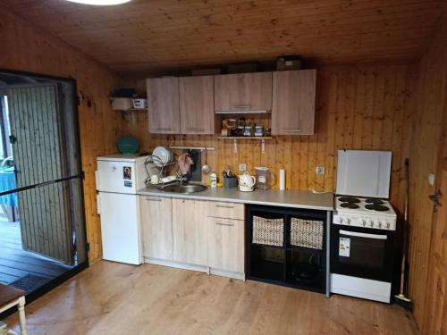 a kitchen with a white refrigerator and a stove at Domek letniskowy in Wójcin