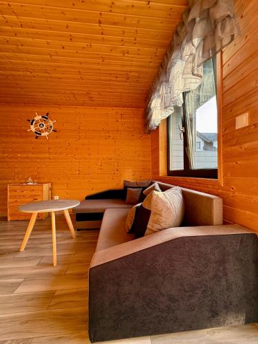 a living room with a couch and a table at Morska Melodia in Sarbinowo