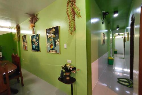 a hallway with a green wall with pictures on it at MilVir Tourist Inn El Nido near Beach in El Nido