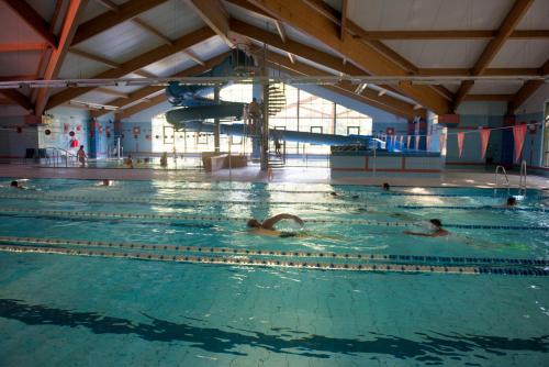 a group of people swimming in a swimming pool at Stacja Nowa Gdynia Bed & Breakfast Aquapark in Łódź