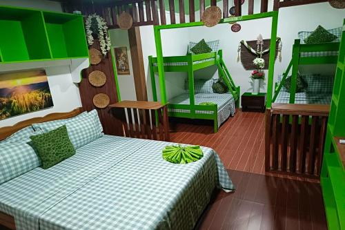 a room with two beds and green bunk beds at MilVir Tourist Inn El Nido near Beach in El Nido