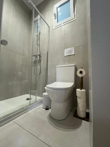 a bathroom with a toilet and a glass shower at Janela para o Atlântico in Porto Moniz