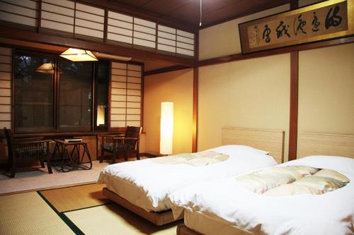 a bedroom with two beds and a table and a dining room at Kawaguchiko Hotel in Fujikawaguchiko