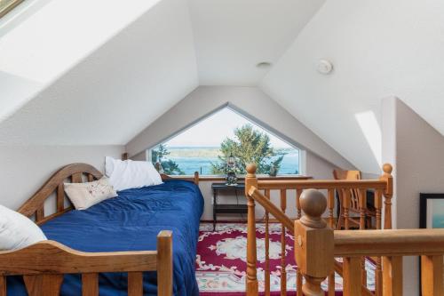 a bedroom with a bed and a large window at Waldport Beach Haven in Waldport