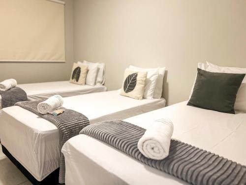 a room with three beds with towels on them at Aurora Serena - Casa com 2 quartos, próximo a rodoviária e aeroporto in Palmas
