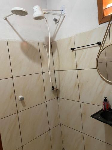 a shower with a shower head in a bathroom at Pousada da vila in Beberibe
