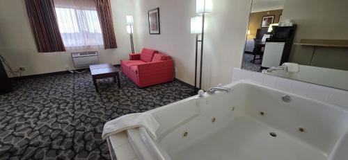 a hotel room with a tub and a red chair at Quality Inn & Suites Eldridge Davenport North in Eldridge