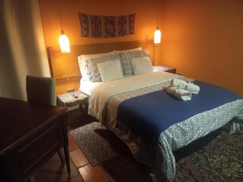 a bedroom with a bed with a blue comforter at Rincon Acogedor in Bogotá