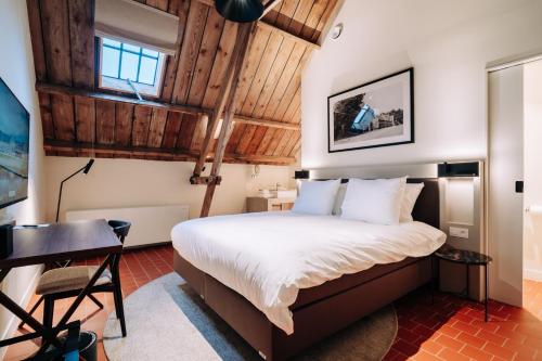 a bedroom with a bed and a desk in a room at Hotel Colonie 7 in Merksplas
