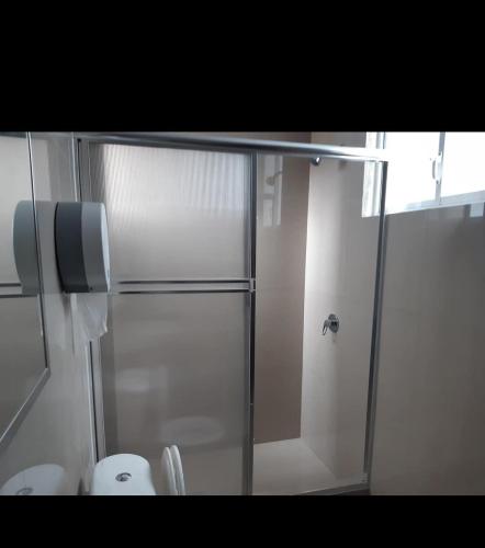 a bathroom with a shower and a toilet at Hostal Iruña in Loja