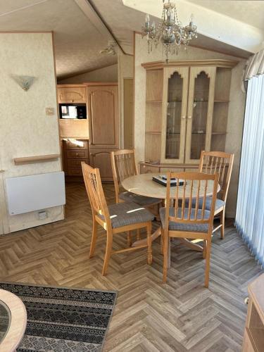 a dining room with a wooden table and chairs at 6 berth caravan ensuite the chase in Ingoldmells