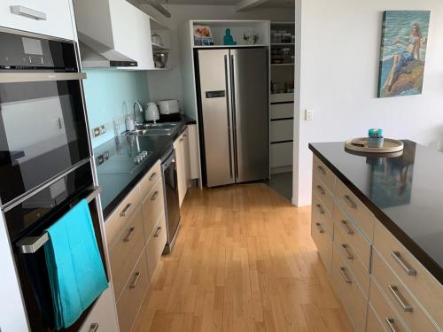 a kitchen with a refrigerator and a wooden floor at The Bay Riveria in Napier