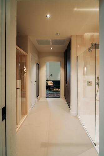 a hallway with a walk in shower and a room with a bedroom at Hotel Colonie 7 in Merksplas