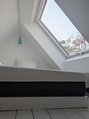 ein Bett in einem Zimmer mit Fenster in der Unterkunft Tiny Villa in Fehmarn