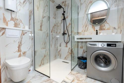 a bathroom with a washing machine and a mirror at Le Nid Doré in Maarif