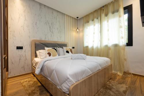 a bedroom with a large bed with white sheets and pillows at Le Nid Doré in Maarif