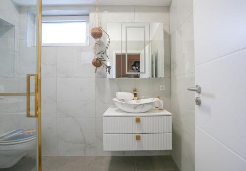 a white bathroom with a sink and a mirror at Hof Friesenruhe – Loft in Högel