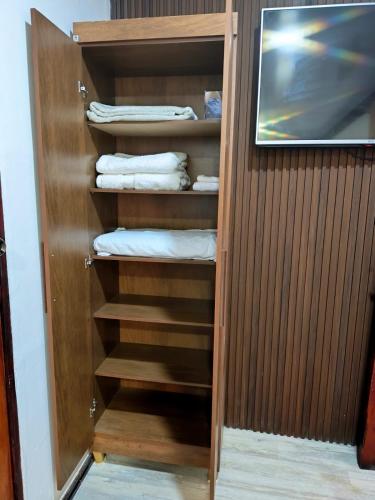 a closet with wooden shelves and towels in it at Cozy Studio Rohrmoser in San José