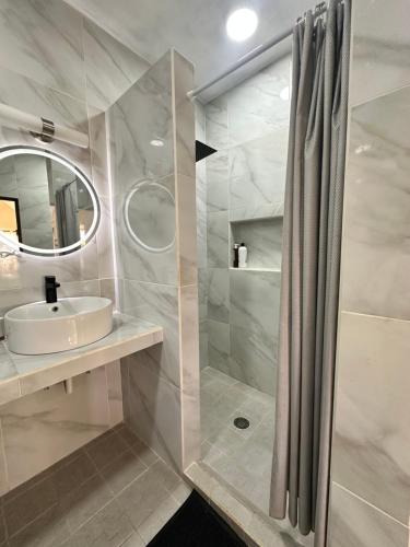 a white bathroom with a sink and a shower at Finca Nona's, Naturaleza y playa in Ciudad Madero