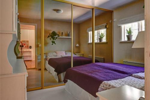 a bedroom with two beds and a mirror at Peaceful Getaway in Åsljunga