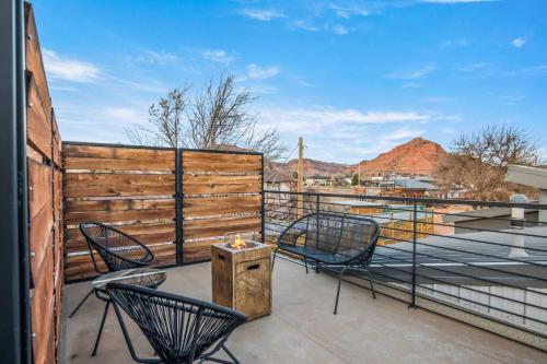 a balcony with two chairs and a wooden fence at Timber & Tin H 2Bed 2Bath w Pool & Rooftop Deck in Kanab