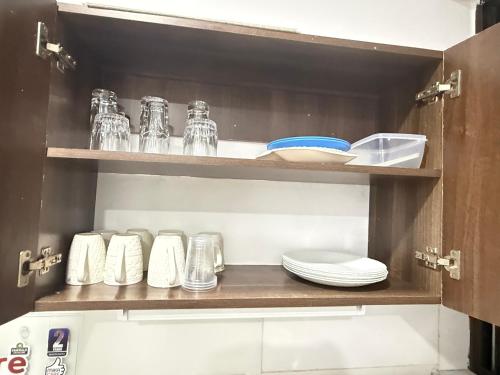 a kitchen shelf with plates and glasses and dishes at KK Homes in Diani Beach