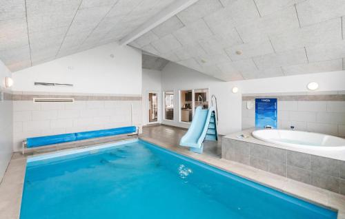 a large bathroom with a swimming pool and a tub at Beach Front Home In Bogense With Sauna in Bogense