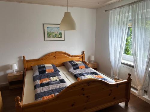 a bedroom with a wooden bed and a window at Idyllische Wohnung in ruhiger Lage Nähe BAB A6! in Illschwang