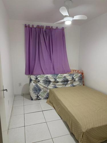 a bedroom with a bed and a purple window at Apartamento enseada in Guarujá