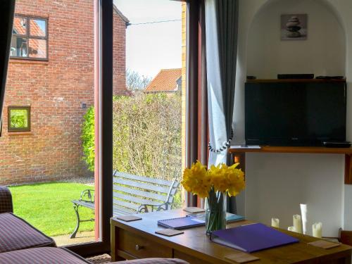 a living room with a table and a large window at Keel Cottage in Whitby